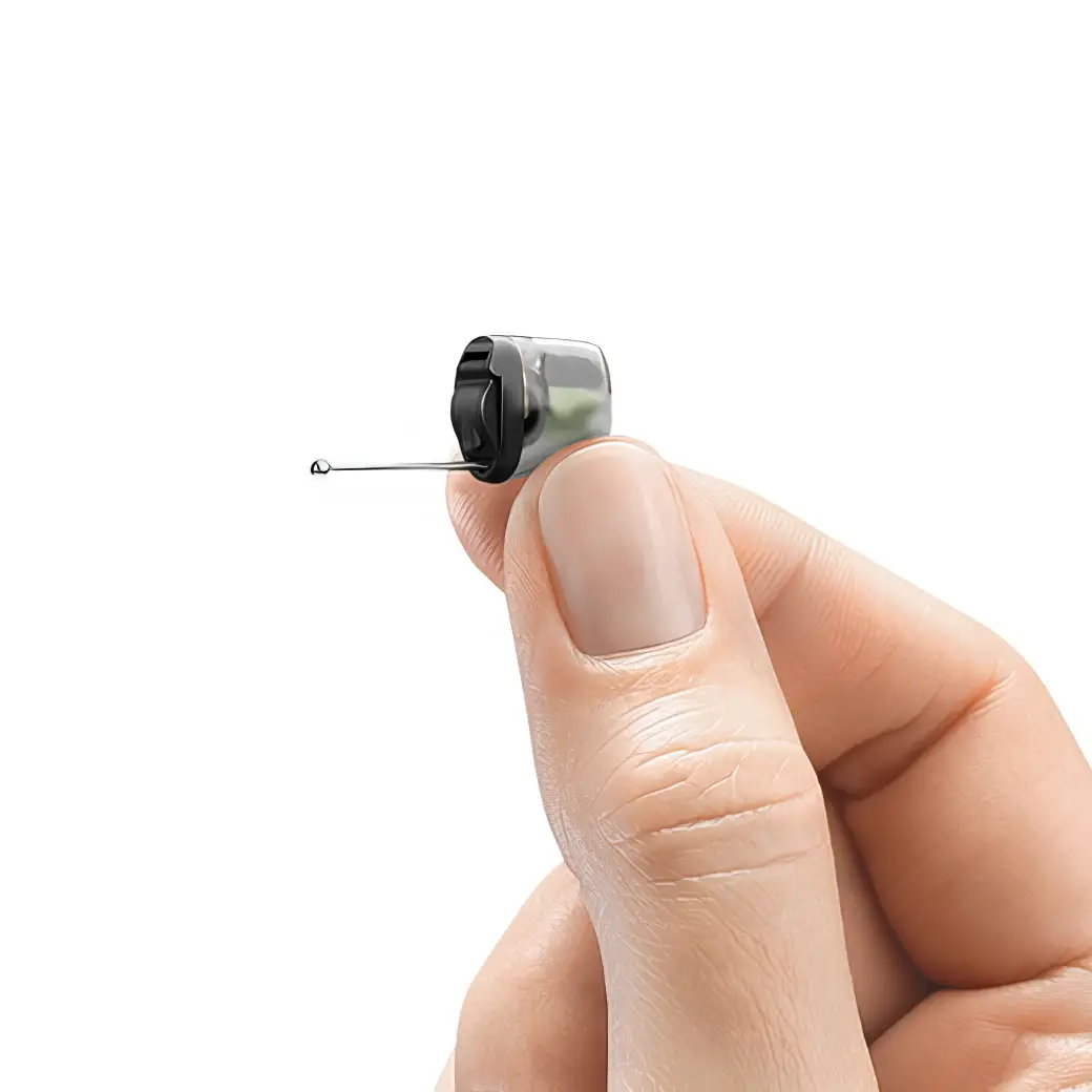 A hand holding a small hearing aid device.